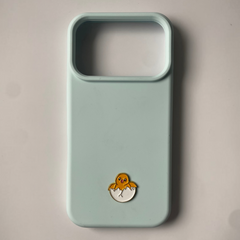 Pinkgul.no light blue phone case with a decorative metal chick in an egg sticker attached to the back