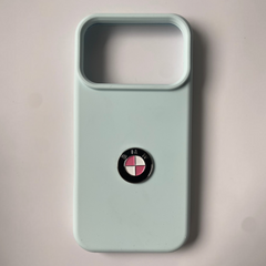 Pinkgul.no light blue phone case featuring a decorative metallic BMW logo sticker with pink and white accents