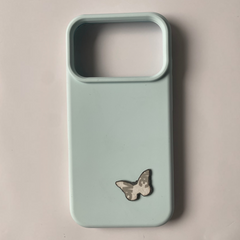 Pinkgul.no light blue phone case with a small, decorative, raised butterfly metal sticker attached to the back.