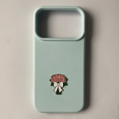 Pinkgul.no light blue phone case featuring a decorative metal sticker of a pink rose bouquet with a white bow.