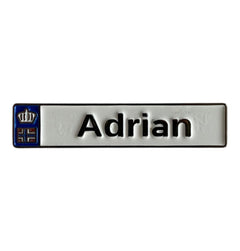 Pinkgul.no Adrian decorative metal sticker with a white surface, black text, and a small crown emblem on the left.