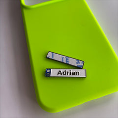 Pinkgul.no Adrian decorative metal sticker with a raised design and adhesive backing on a neon green phone case