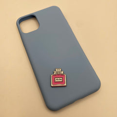 Pinkgul.no blue phone case decorated with a small, raised pink and gold metal perfume bottle sticker