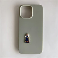 Pinkgul.no decorative metal sticker featuring a traditional blue bunad dress design applied to a sage green phone case.