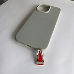 Pinkgul.no metal sticker featuring a red traditional Norwegian Bunad dress design placed next to a light green phone case