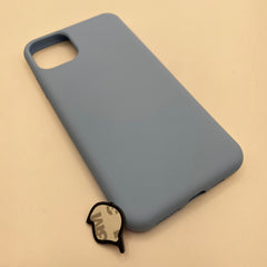 Pinkgul.no decorative metal sticker with adhesive backing placed next to a light blue silicone smartphone case