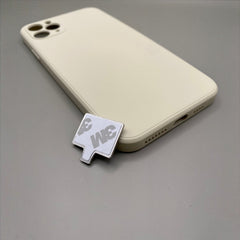 Pinkgul.no decorative metal sticker with strong adhesive backing, shown next to a cream-colored smartphone case.