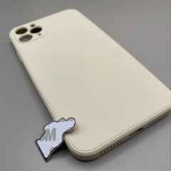 Pinkgul.no decorative metal sticker with adhesive backing placed next to a cream-colored smartphone case