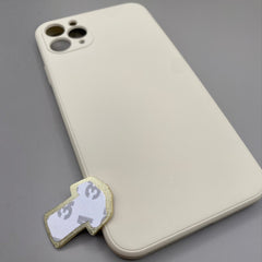 Pinkgul.no decorative gold metal sticker with adhesive backing placed next to a beige smartphone case