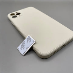 Pinkgul.no decorative silver metal sticker with 3M adhesive backing placed next to a beige smartphone case.
