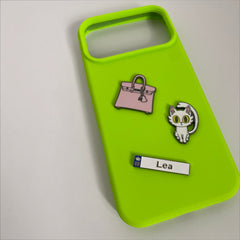 Pinkgul.no decorative metal stickers including a pink handbag, a white cat, and a name tag on a lime green phone case