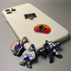 Pinkgul.no decorative metal stickers featuring gym and basketball themes applied to a beige smartphone case