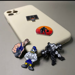 Pinkgul.no decorative metal stickers featuring gym and basketball themes applied to a beige smartphone case.