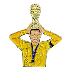 Pinkgul.no decorative metal sticker featuring a football player in a yellow jersey holding a gold trophy overhead.