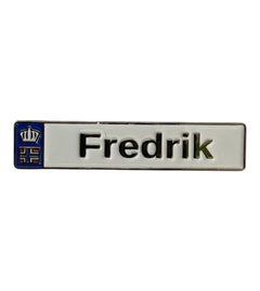 Pinkgul.no Fredrik decorative metal sticker with a white background, blue emblem, and raised metallic lettering.
