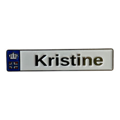 Pinkgul.no Kristine decorative metal sticker with a small blue crown emblem and raised lettering on a white background