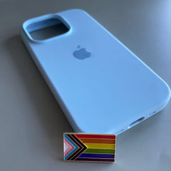 Pinkgul.no LGBTQ pride flag metal sticker with raised design placed next to a light blue smartphone case