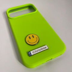 Pinkgul.no lime green phone case with a smiley face and a decorative Christine metal sticker attached.