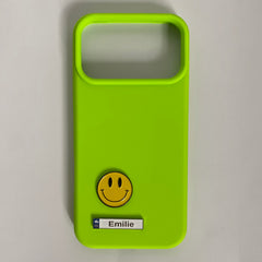 Pinkgul.no lime green phone case featuring a yellow smiley face metal sticker and a name tag labeled Emilie.