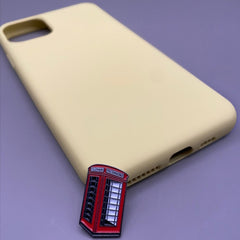 Pinkgul.no decorative metal sticker featuring a red London telephone booth design placed next to a beige phone case.