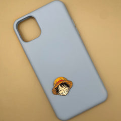 Pinkgul.no decorative metal sticker featuring Luffy from One Piece applied to a light blue smartphone case