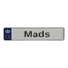 Pinkgul.no Mads decorative metal sticker with a white finish, blue crown emblem, and raised black lettering.