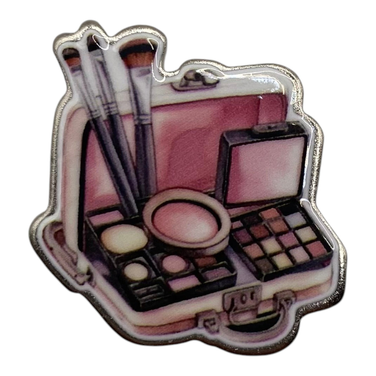 Pinkgul.no decorative metal sticker featuring a pink makeup case with brushes and cosmetics palettes