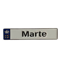 Pinkgul.no Marte decorative metal sticker with a white surface, black text, and a small blue crown emblem.