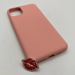 Pinkgul.no decorative metal sticker with a red lip design placed next to a matching pink smartphone case