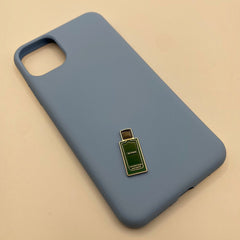Pinkgul.no decorative metal sticker shaped like a green perfume bottle attached to a light blue smartphone case