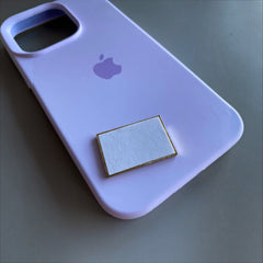 Pinkgul.no rectangular metal sticker with adhesive backing placed on a light purple iPhone case