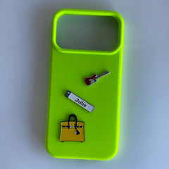 Pinkgul.no neon green phone case decorated with metal stickers including a guitar, a name tag, and a yellow handbag.
