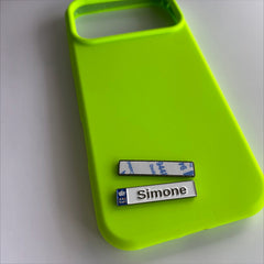 Pinkgul.no Simone decorative metal sticker with a white finish and crown icon, applied to a neon green phone case.
