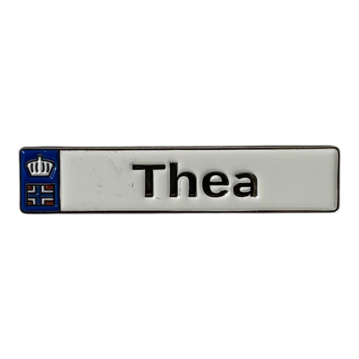 Pinkgul.no Thea decorative metal sticker with a white background, black text, and a small crown and flag emblem.