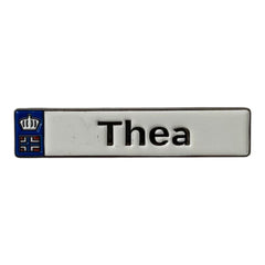 Pinkgul.no Thea decorative metal sticker with a white background, black text, and a small crown and flag emblem.